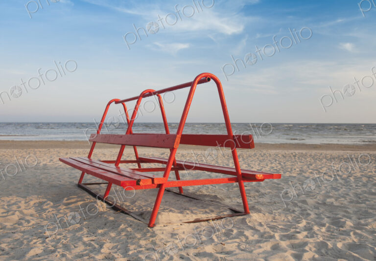Red Park Bench on the Beach