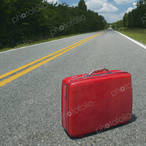 Red Suitcase Abandoned in Road