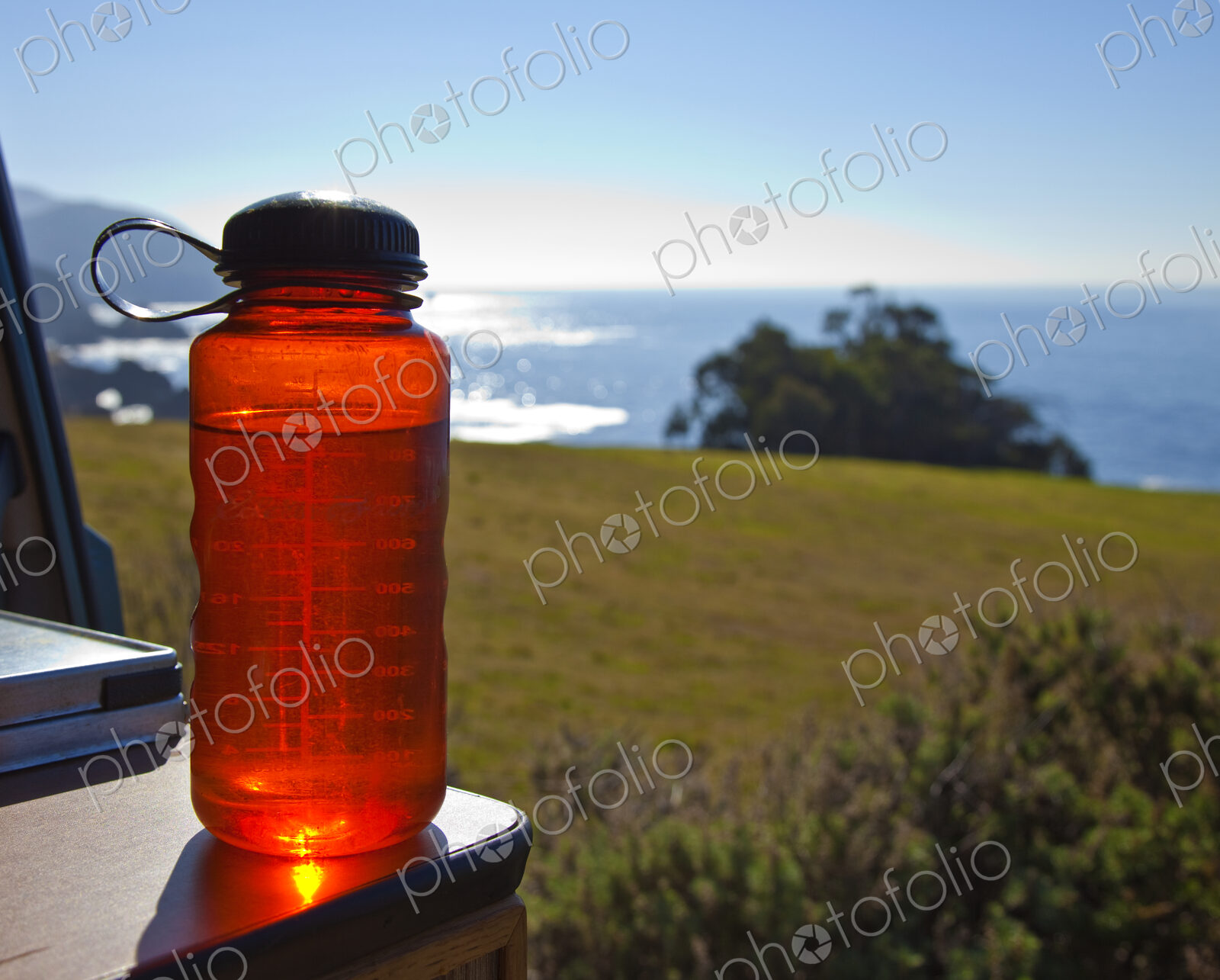 Red Water Bottle with Ocean in Background