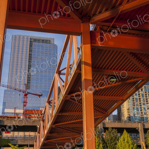 Red bridge seen from below with high rise buildings and contruction sites in background. Red bridge seen from below with high rise buildings and contruction sites in background.