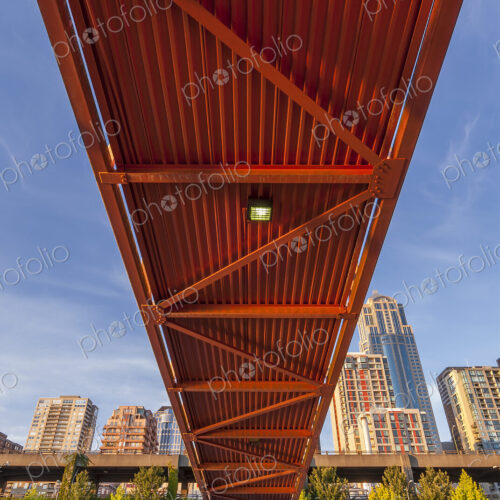 Red bridge seen from below with high rise buildings and contruction sites in background. Red bridge seen from below with high rise buildings and contruction sites in background.