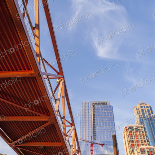 Red bridge seen from below with high rise contruction sites in background. Red bridge seen from below with high rise contruction sites in background.