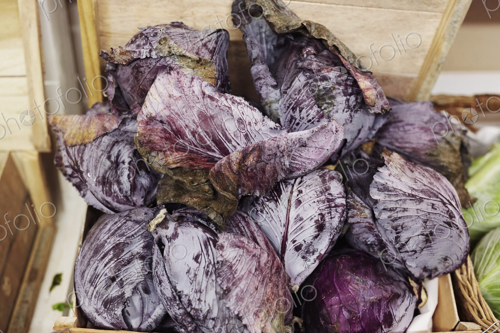 Red cabbages piled up in a wooden crate.