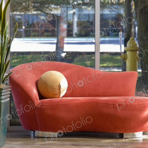 Red chaise longue and potted plant in office or hotel lobby. Red chaise longue and potted plant in office or hotel lobby.