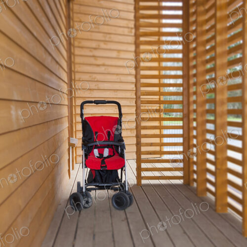 Red child's buggy at the buggy bay at a pre-school or children's day care nursery Red child's buggy at the buggy bay at a pre-school or children's day care nursery