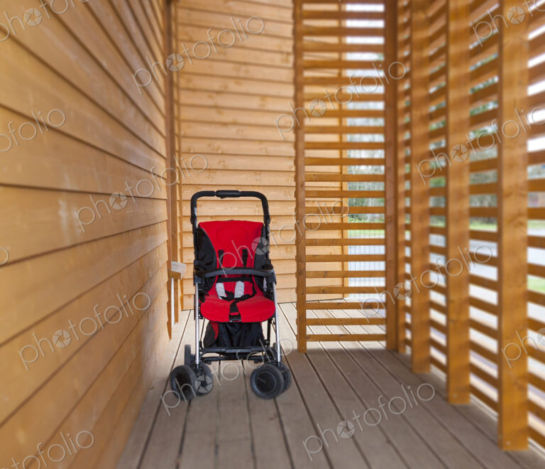 Red child's buggy at the buggy bay at a pre-school or children's day care nursery