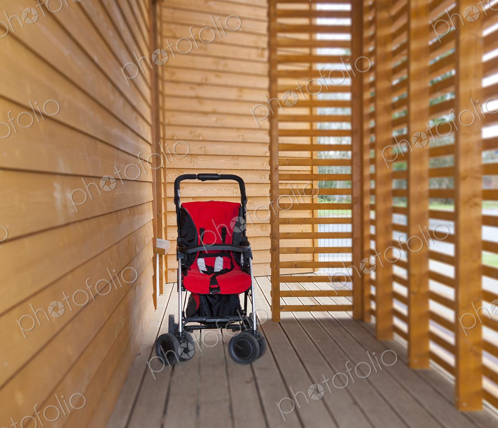 Red child’s buggy at the buggy bay at a pre-school or children’s day care nursery