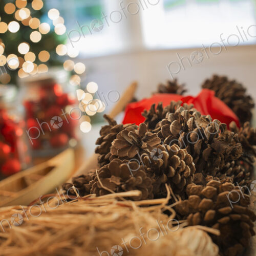 Red glass balls and pine cones. Christmas decorations and a Christmas tree.