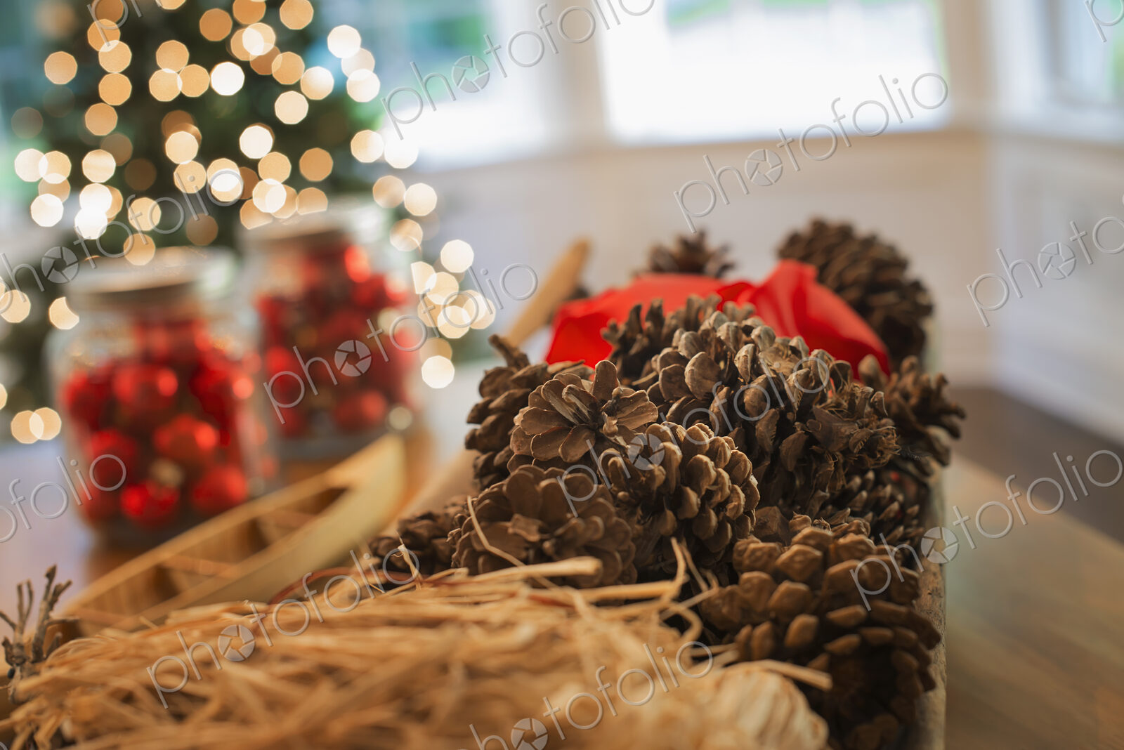 Red glass balls and pine cones. Christmas decorations and a Christmas tree.