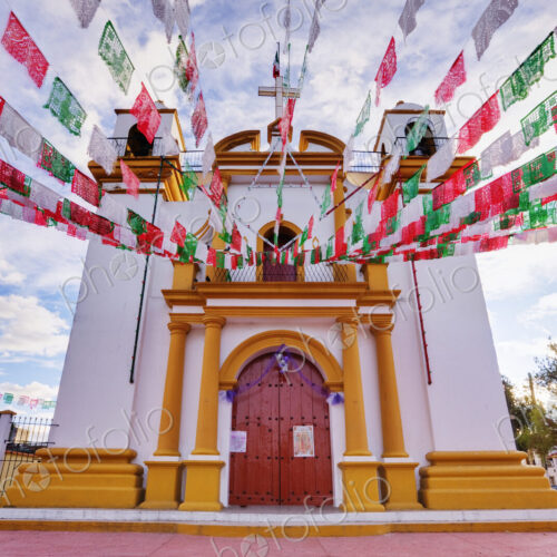 Red, white and green banners on church, Chiapas, Mexico