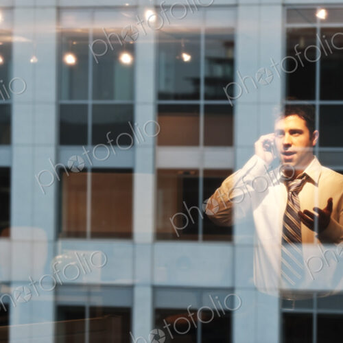 Reflection in windows of a businessman working late at night