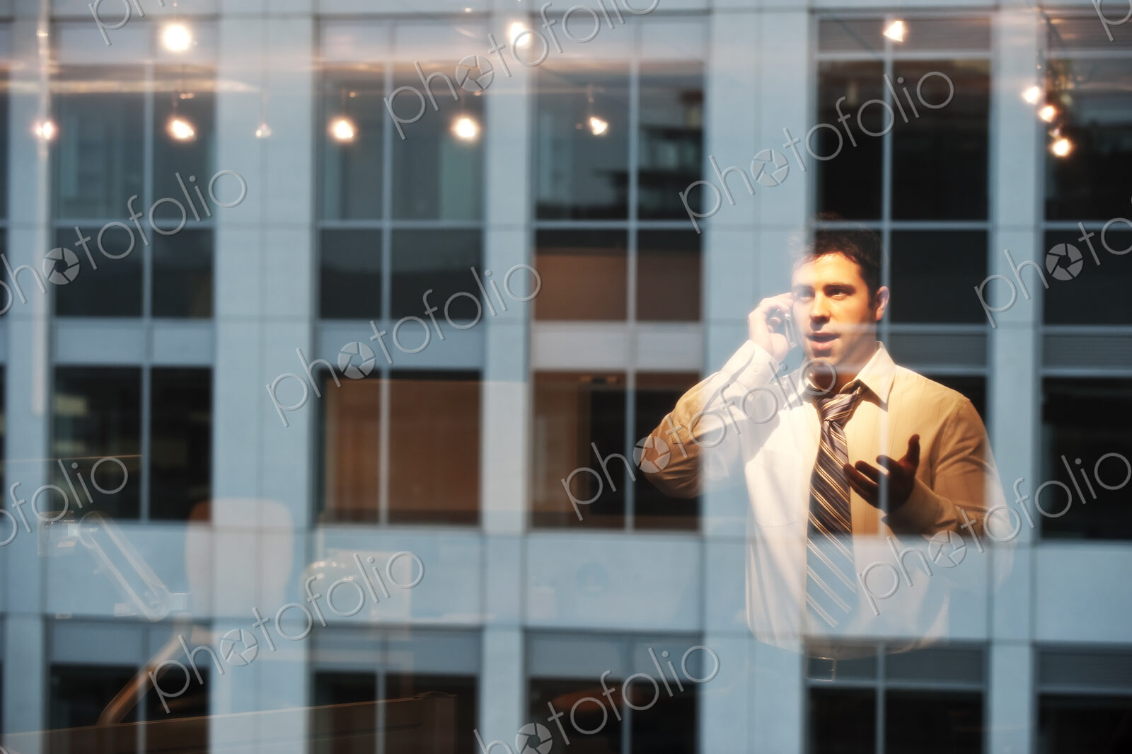 Reflection in windows of a businessman working late at night
