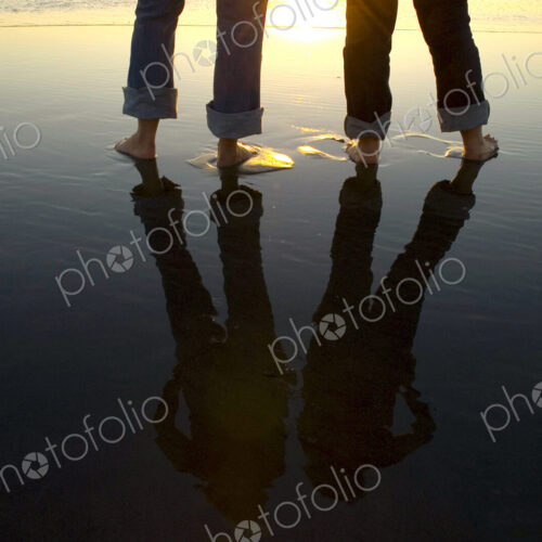 Reflection of legs in water at beach Reflection of legs in water at beach