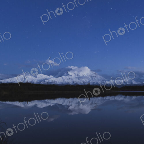 Reflection of scenic view of mountain in pond