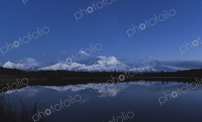 Reflection of scenic view of mountain in pond