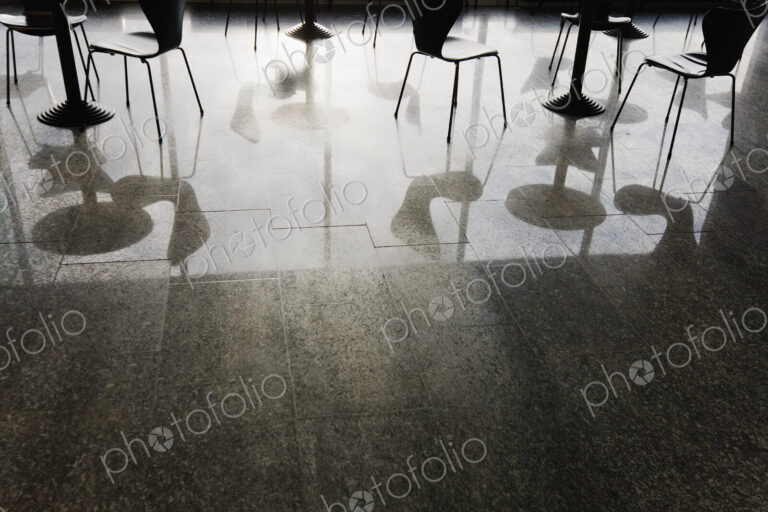 Reflections of Tables and Chairs on Shiny Floor