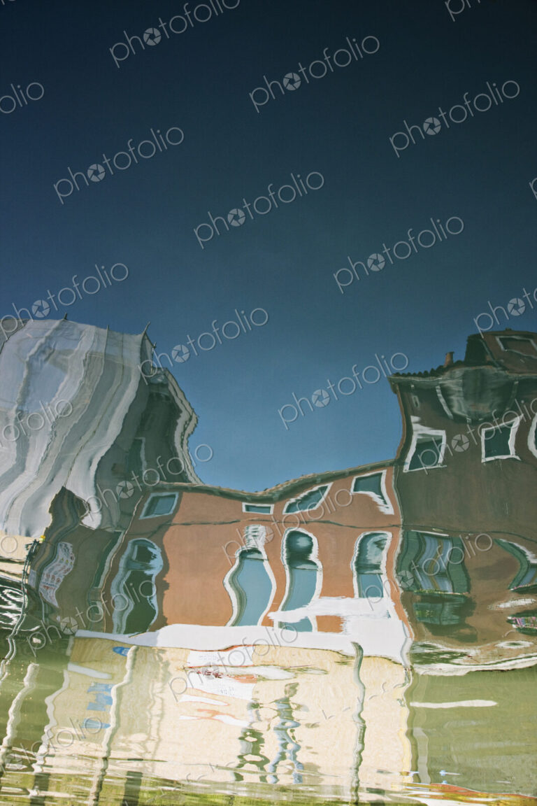 Reflections of buildings in canal water.