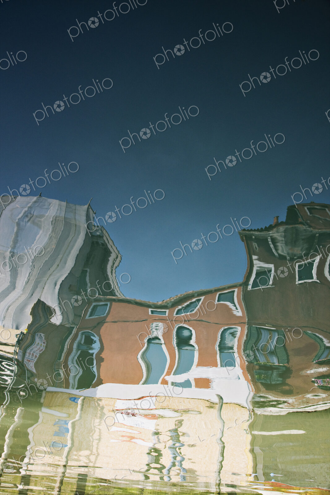 Reflections of buildings in canal water.