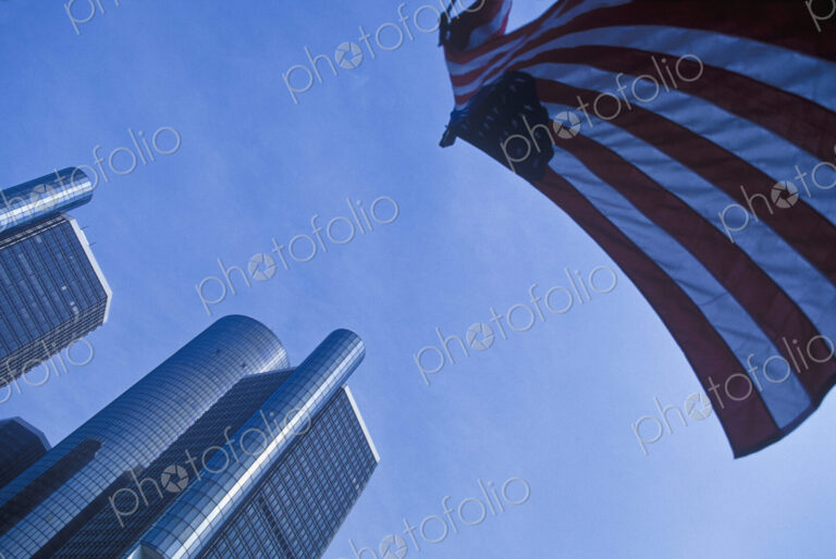 Renaissance Center, tall buildings, low angle view and American flag flying.