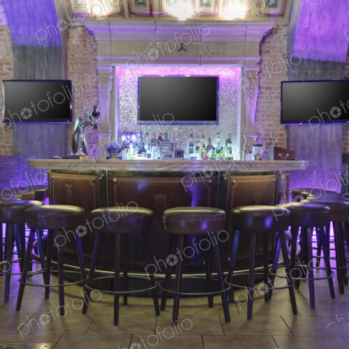 Restaurant interior illuminated with purple lights.