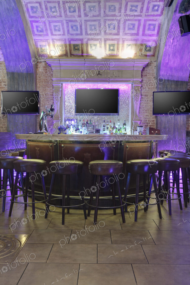 Restaurant interior illuminated with purple lights.