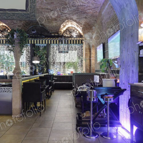 Restaurant interior illuminated with purple lights.