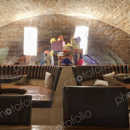 Restaurant leather seats with heap of giftboxes among them against mirror.