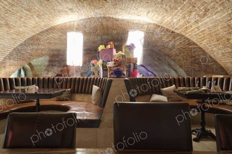 Restaurant leather seats with heap of giftboxes among them against mirror.
