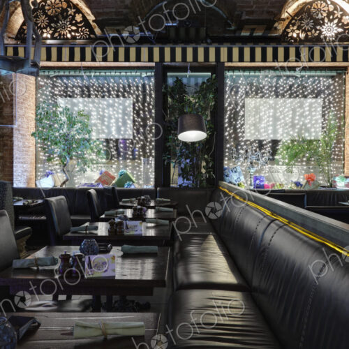 Restaurant with windows decorated with gift boxes and illumination.