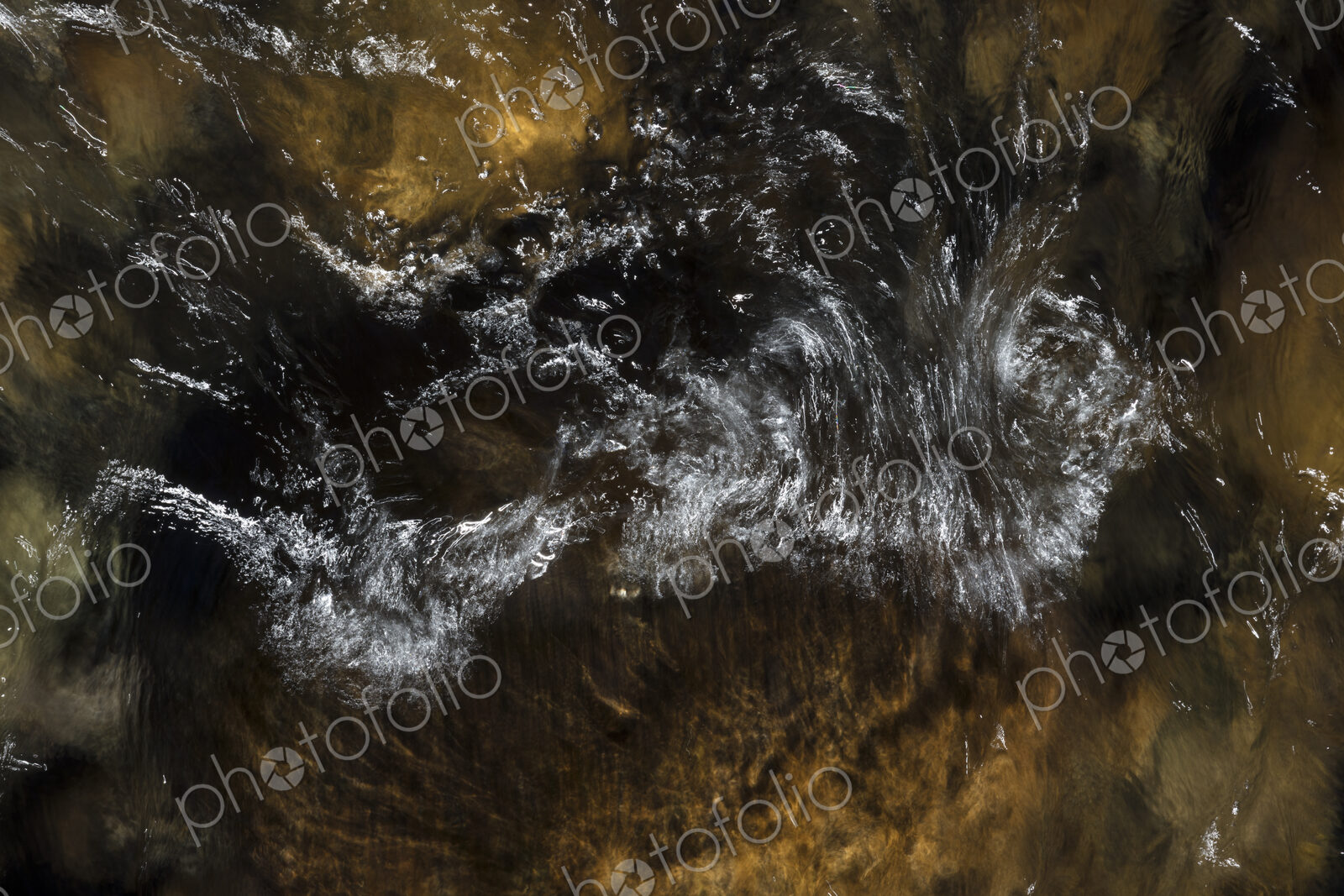 River water abstract, long exposure of river water flowing over boulders and rocks