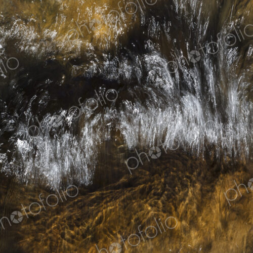 River water abstract, long exposure of river water flowing over boulders and rocks River water abstract, long exposure of river water flowing over boulders and rocks
