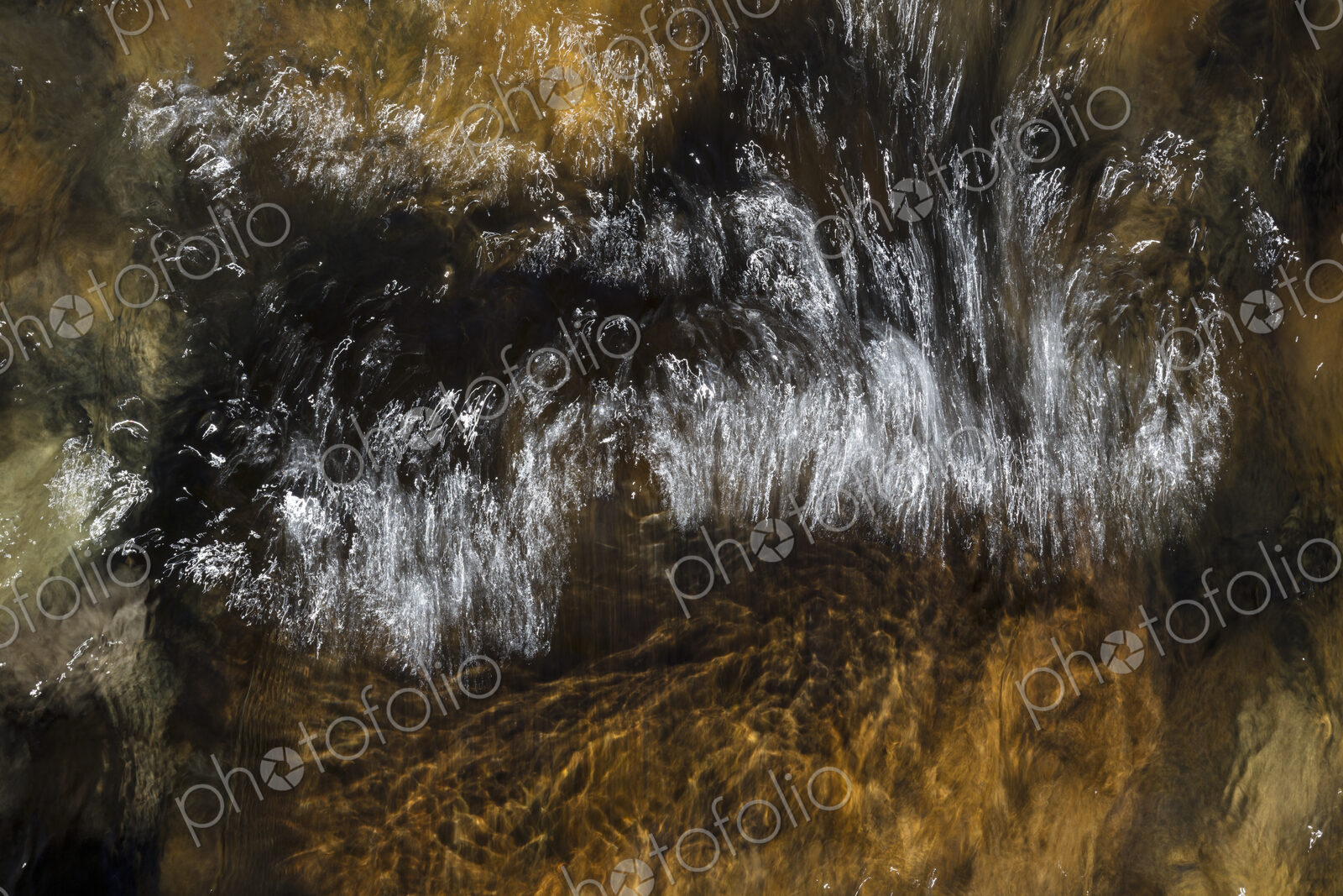 River water abstract, long exposure of river water flowing over boulders and rocks