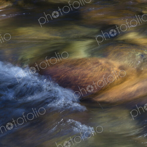 River water abstract, long exposure of river water flowing over boulders and rocks River water abstract, long exposure of river water flowing over boulders and rocks
