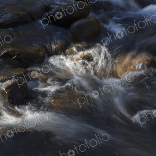 River water abstract, long exposure of river water flowing over boulders and rocks River water abstract, long exposure of river water flowing over boulders and rocks