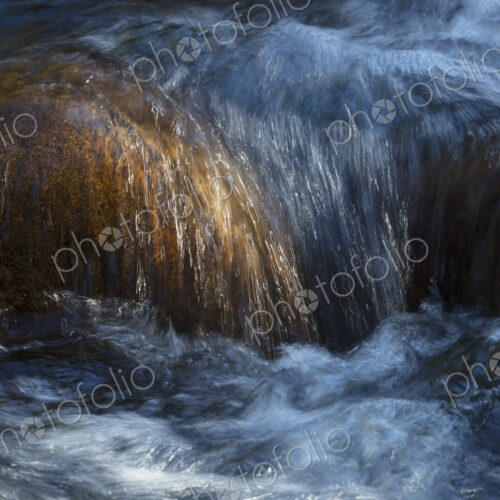 River water abstract, long exposure of river water flowing over boulders and rocks River water abstract, long exposure of river water flowing over boulders and rocks