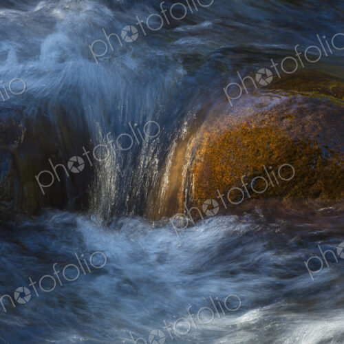 River water abstract, long exposure of river water flowing over boulders and rocks River water abstract, long exposure of river water flowing over boulders and rocks