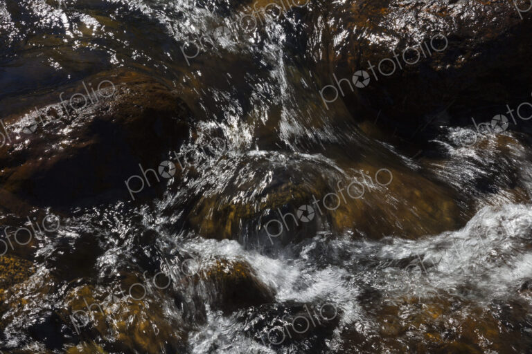 River water abstract, long exposure of river water flowing over boulders and rocks