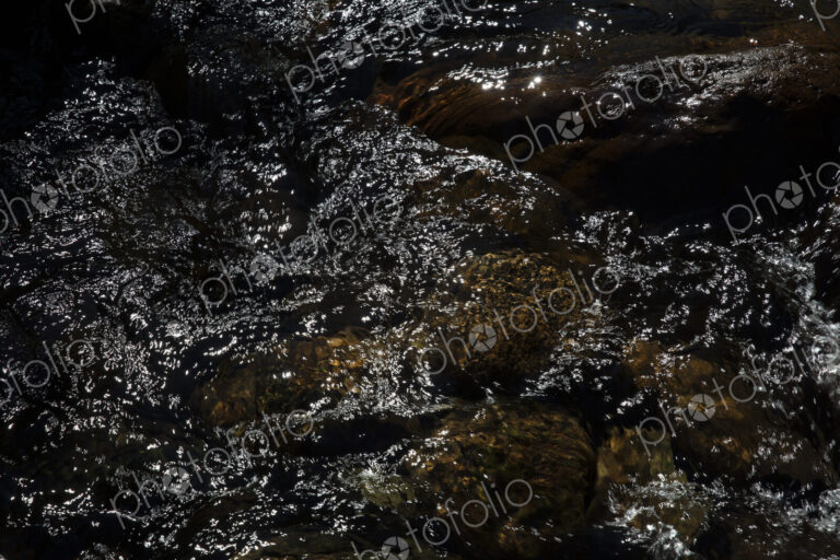 River water abstract, long exposure of river water flowing over boulders and rocks