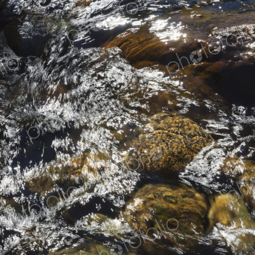 River water abstract, long exposure of river water flowing over boulders and rocks River water abstract, long exposure of river water flowing over boulders and rocks
