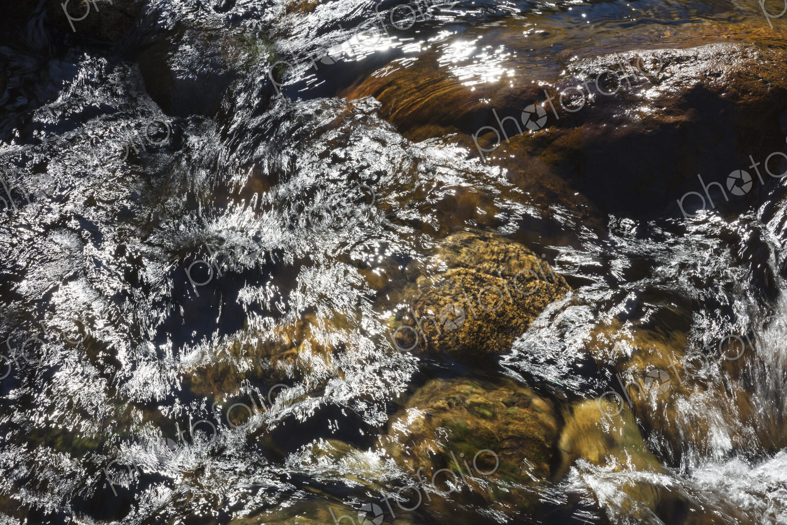 River water abstract, long exposure of river water flowing over boulders and rocks