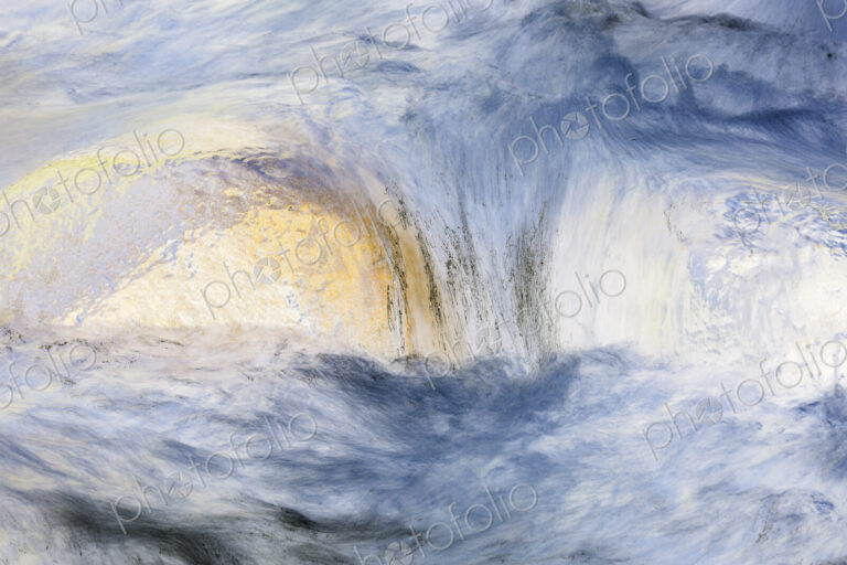 River water abstract, long exposure of river water flowing over boulders and rocks,…