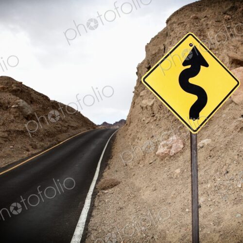 Road and Road Sign showing winding road ahead, Death Valley National Park, Death…