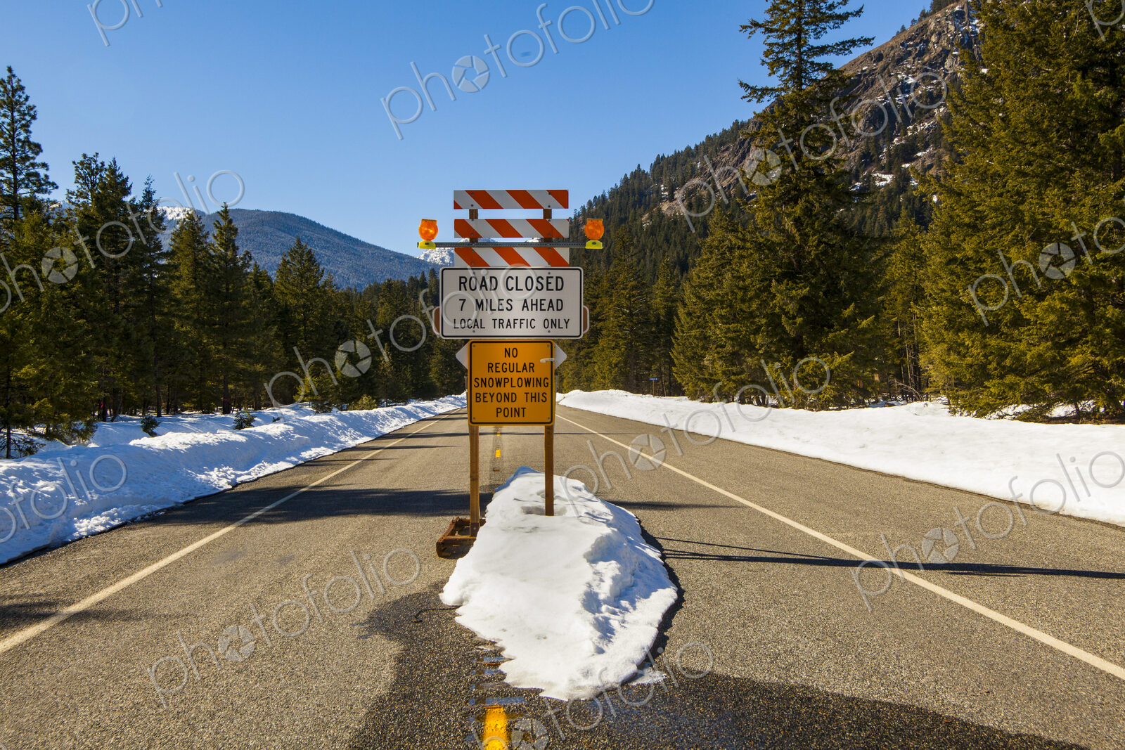 Road closed sign in mountains, North Cascades Highway, winter time, snow drifts.