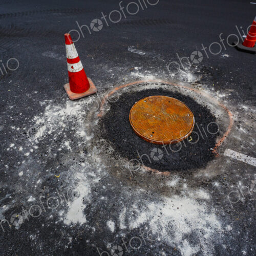 Road construction over sewer manhole cov, WA USA