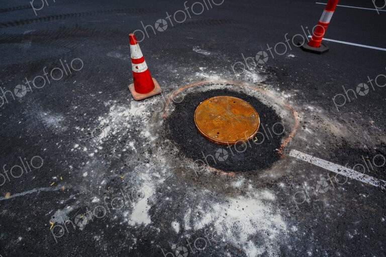 Road construction over sewer manhole cov, WA USA