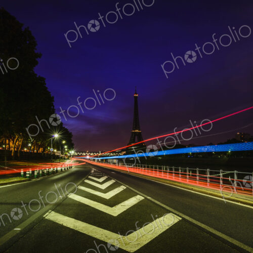 Road markings and coloured light trails at night on a straight road in Paris. Road markings and coloured light trails at night on a straight road in Paris.