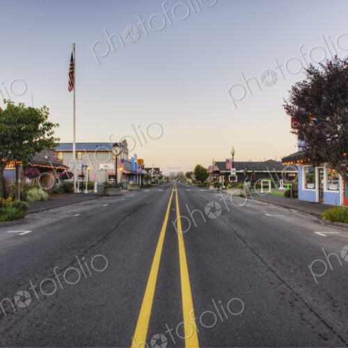 Road on main street running through empty town at dawn. Road on main street running through empty town at dawn.