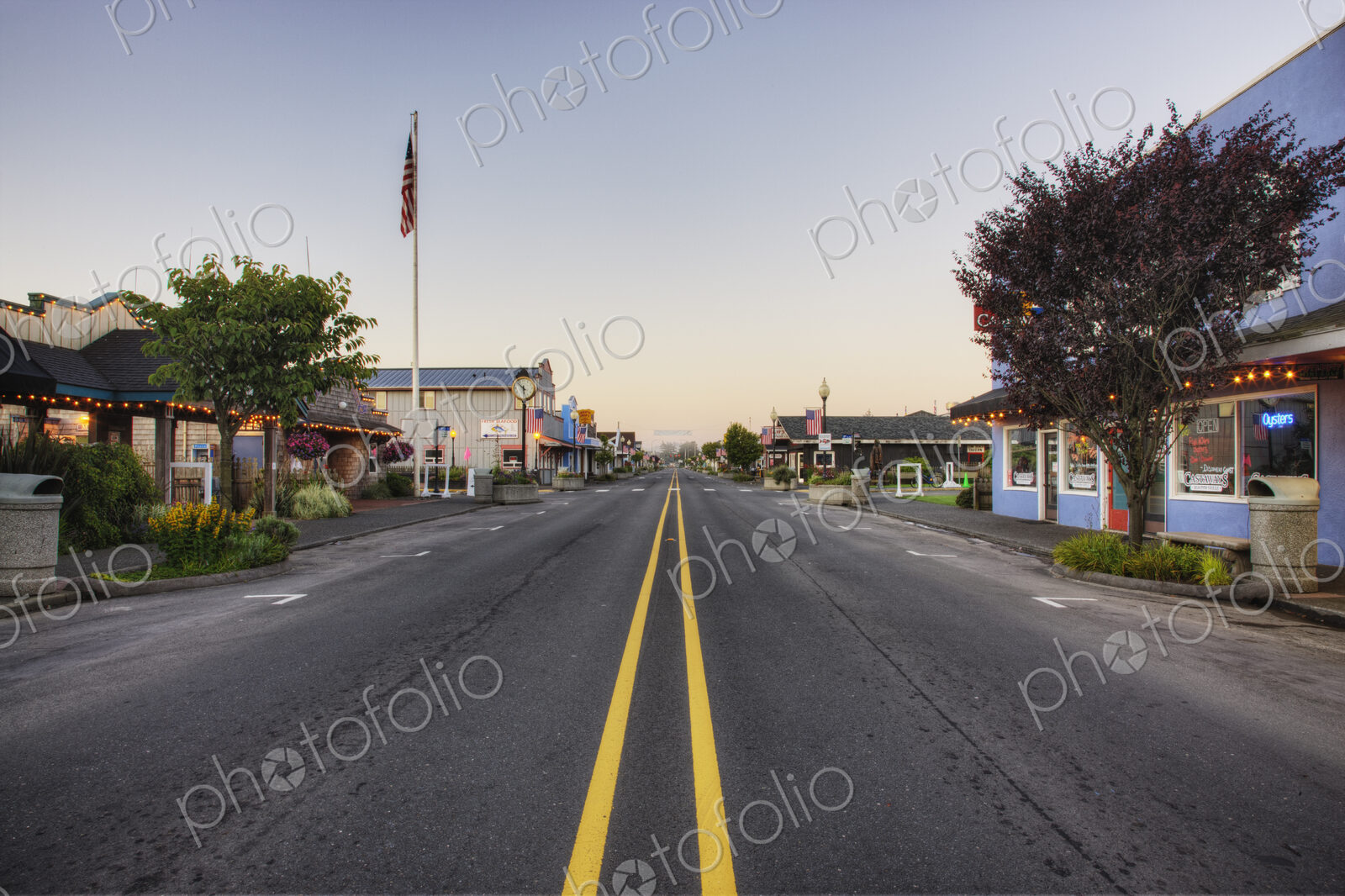 Road on main street running through empty town at dawn.