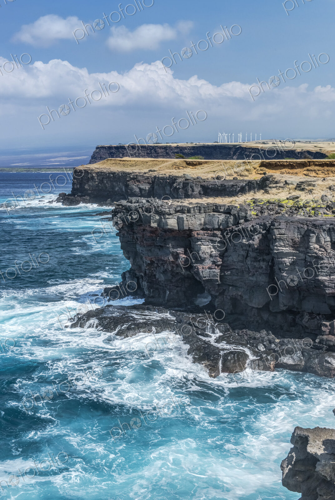 Rocky cliff at South Point, wind farm on the cliff top