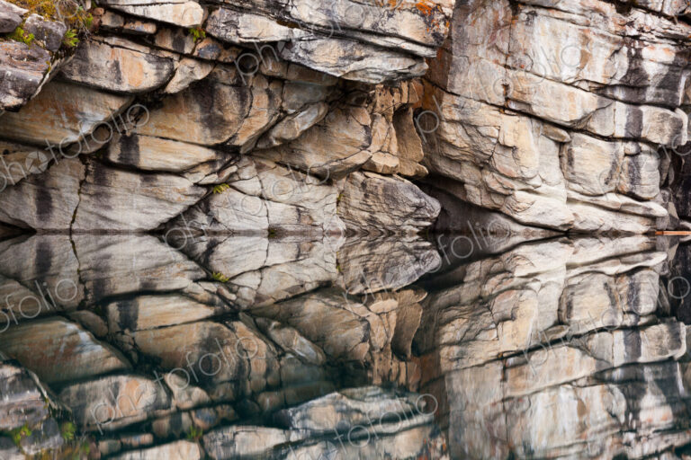 Rocky cliffs perfectly reflected in the calm waters of Horseshoe Lake, Jasper National…